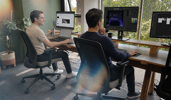 Dos consultores de Remedia trabajando en sus estaciones de diseño